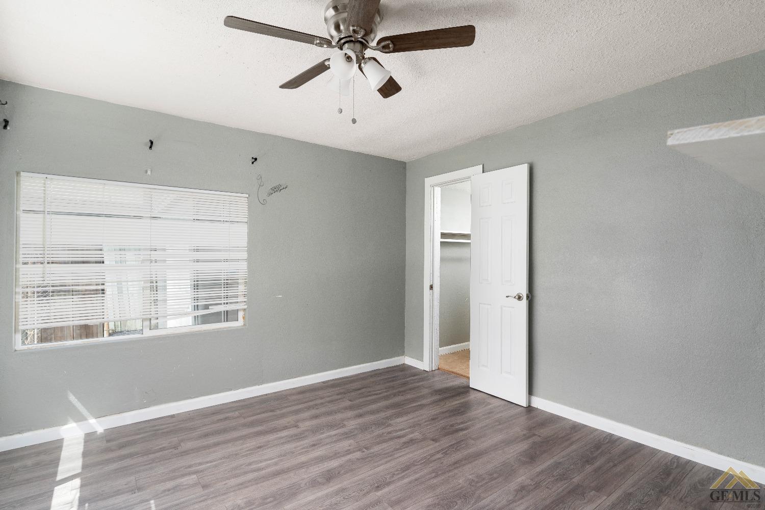 Undisclosed Address Bakersfield, CA 93308 - Photo 6 of 12 a view of an empty room with wooden floor and a window