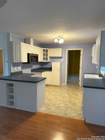 a large kitchen with kitchen island a sink a stove a counter space and cabinets