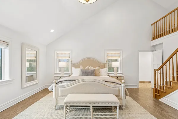 a bedroom with a bed and wooden floor