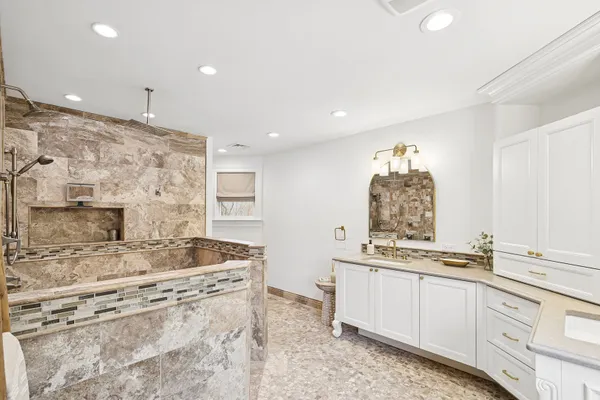 a kitchen with stainless steel appliances kitchen island granite countertop a stove and white cabinets