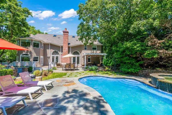 a view of a swimming pool with lounge chairs in patio