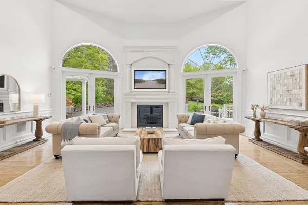 a living room with furniture fireplace and a large window
