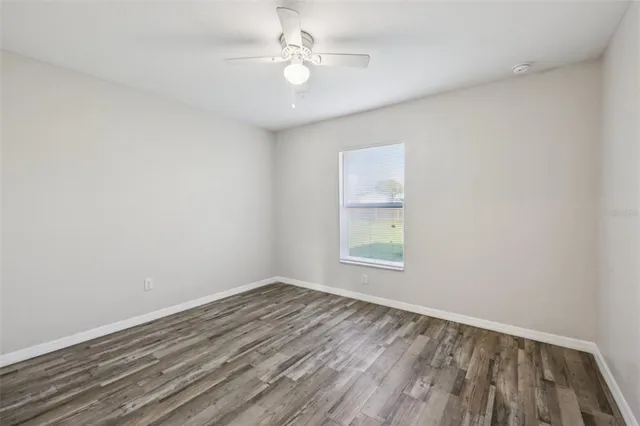 an empty room with a window and a fan