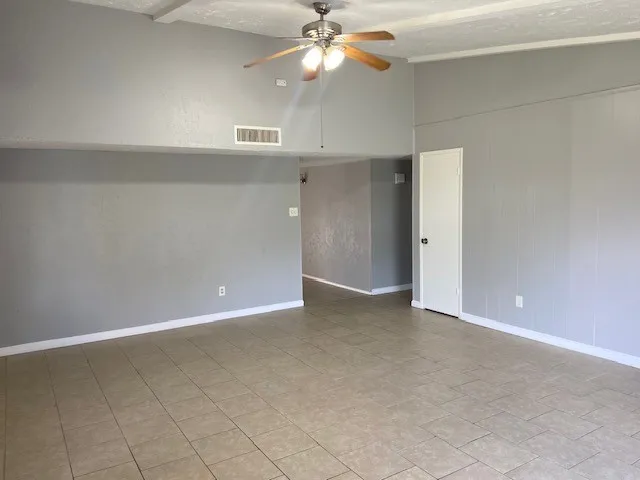 an empty room with closet and a chandelier fan