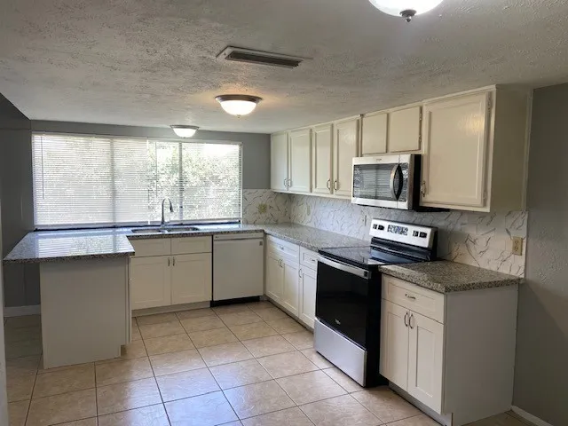 a kitchen with a sink window and cabinets