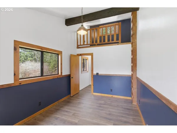a view of an empty room with window and cabinet