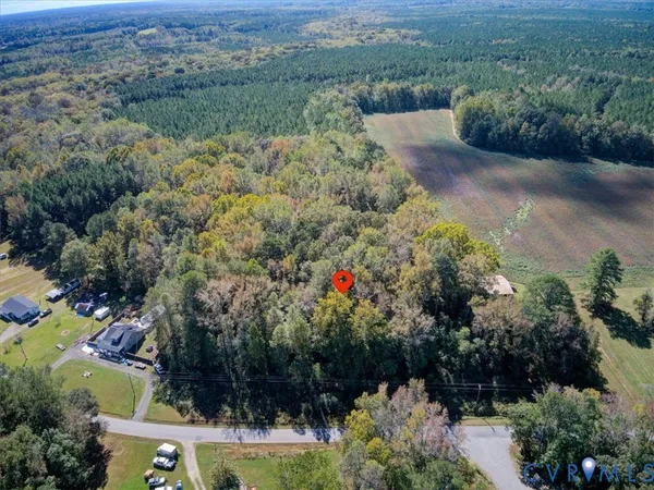 an aerial view of residential house with outdoor space and trees all around