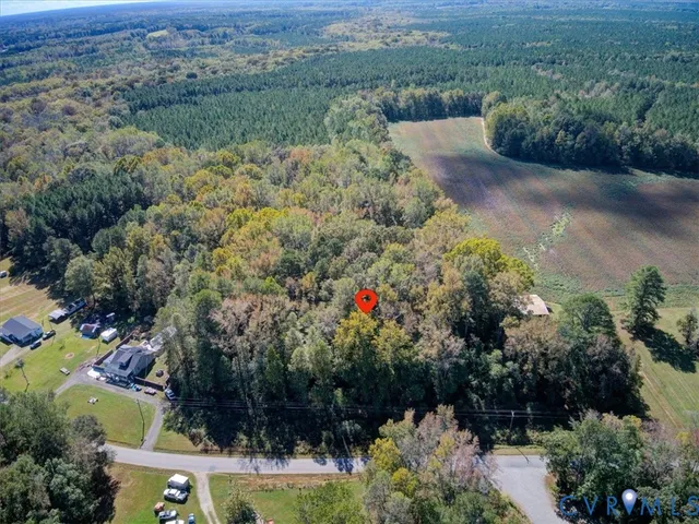 an aerial view of residential house with outdoor space and trees all around