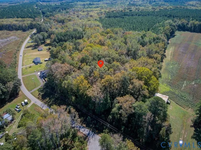 an aerial view of residential house with outdoor space and trees all around