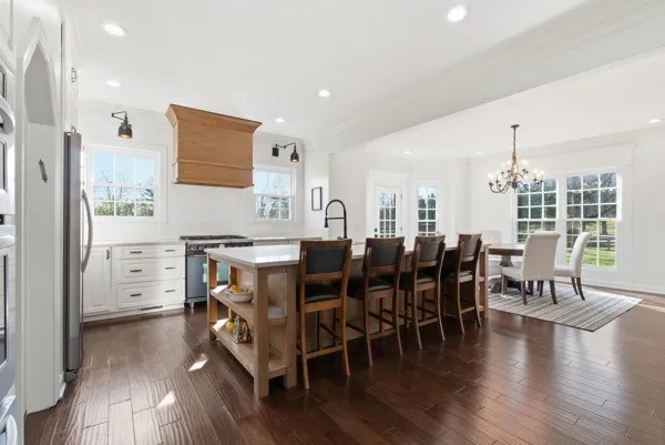a view of a dining room with furniture a chandelier and wooden floor