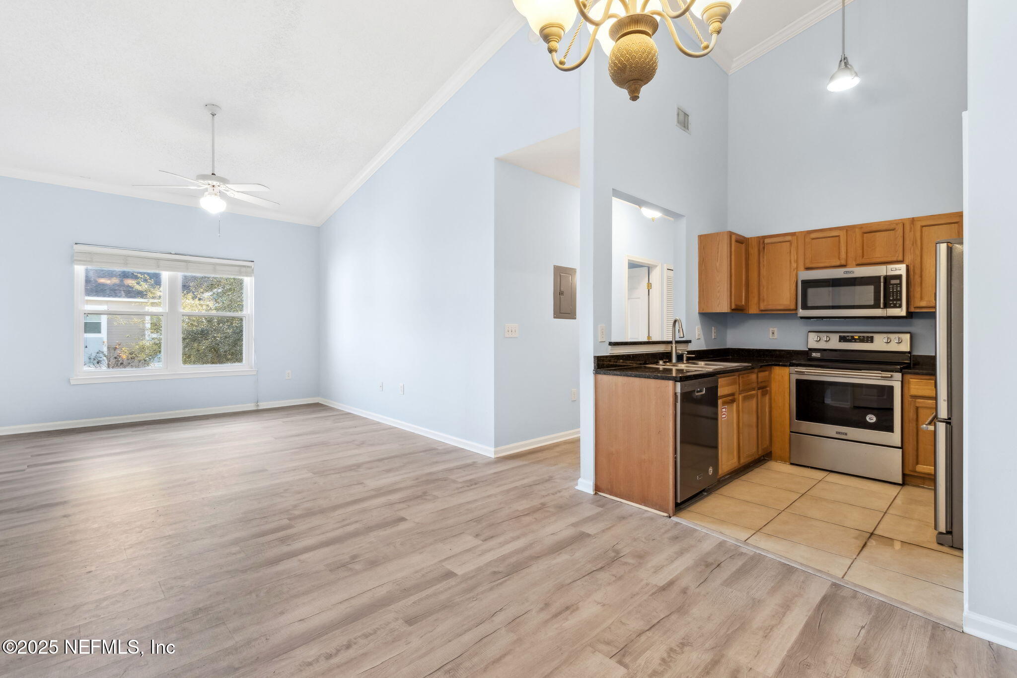 1601 Nectarine Street, Unit F6 Fernandina Beach, FL 32034 - Photo 15 of 57 a kitchen with stainless steel appliances kitchen island granite countertop a stove a sink and a microwave