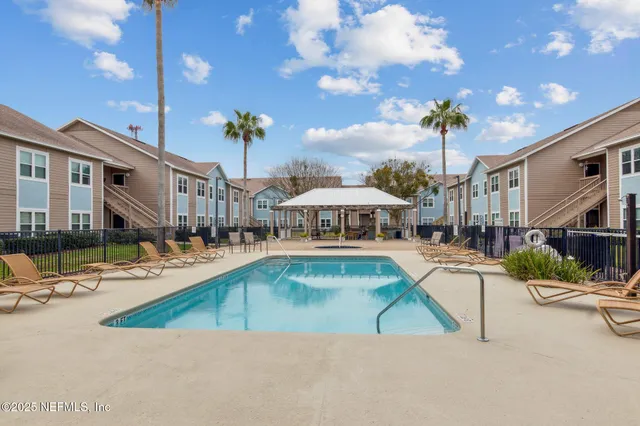 a view of a house with swimming pool and sitting area