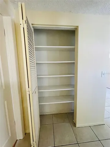 an empty room with wooden floor and windows with curtains