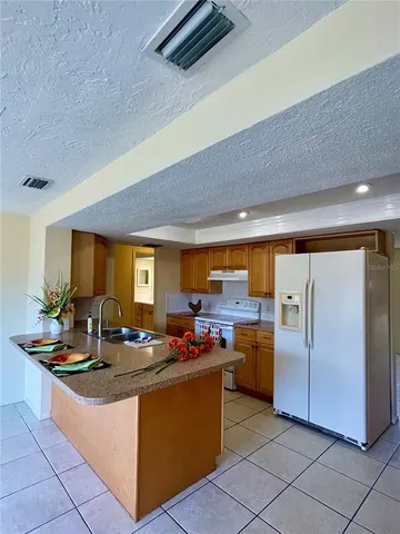 a kitchen with stainless steel appliances granite countertop a sink and a refrigerator