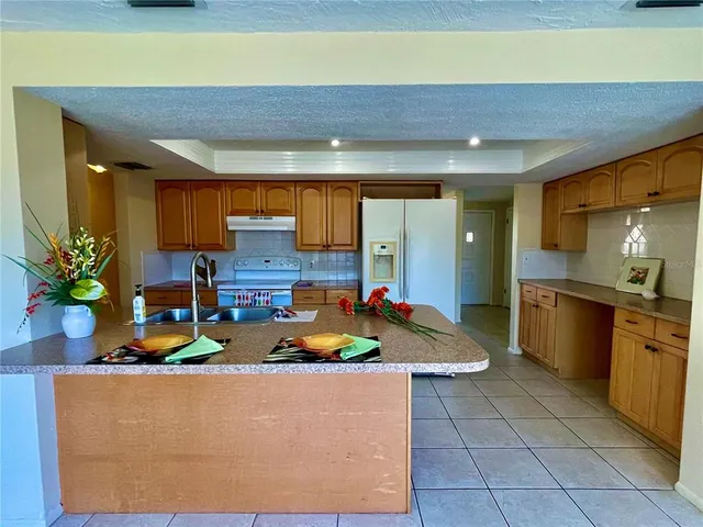 a kitchen with stainless steel appliances granite countertop a sink a stove top oven a counter space and cabinets