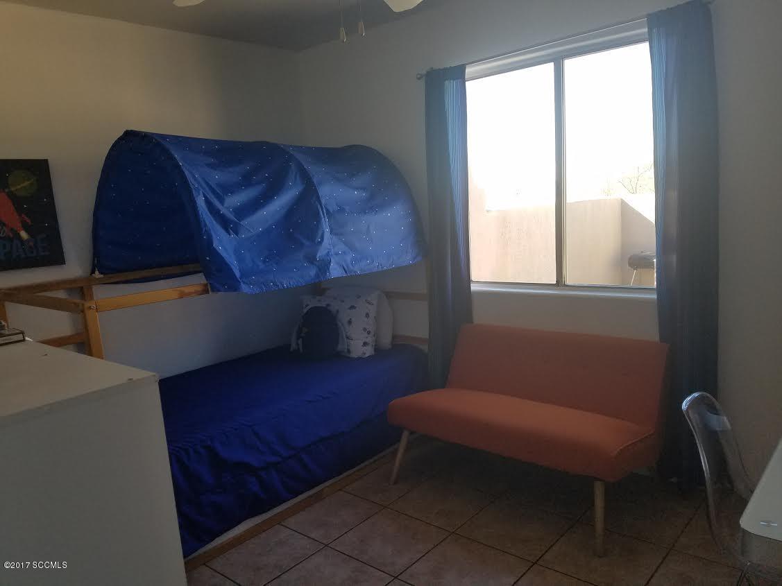 303 Camino Apolena Rio Rico, AZ 85648 - Photo 11 of 15 a blue chair sitting in a room next to a window