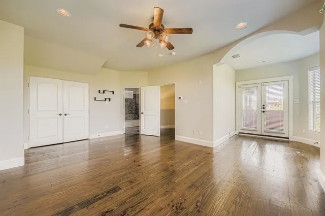 a view of an empty room with window and wooden floor
