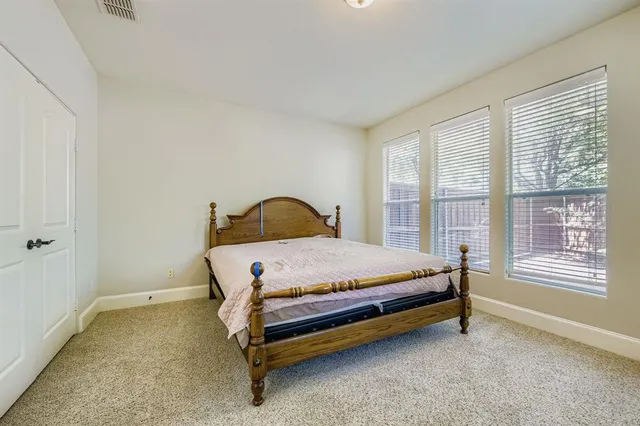 a bed sitting in a bedroom next to a window