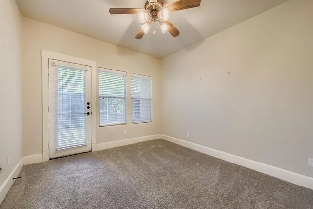an empty room with chandelier fan