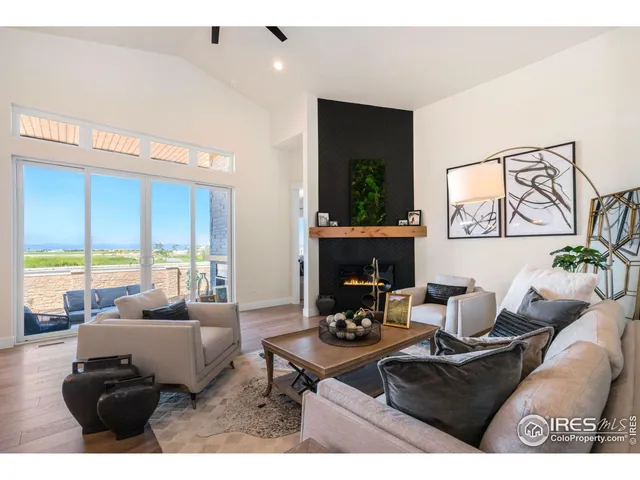 a living room with furniture a fireplace and a large window