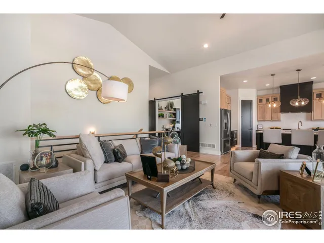 a living room with furniture kitchen view and a chandelier