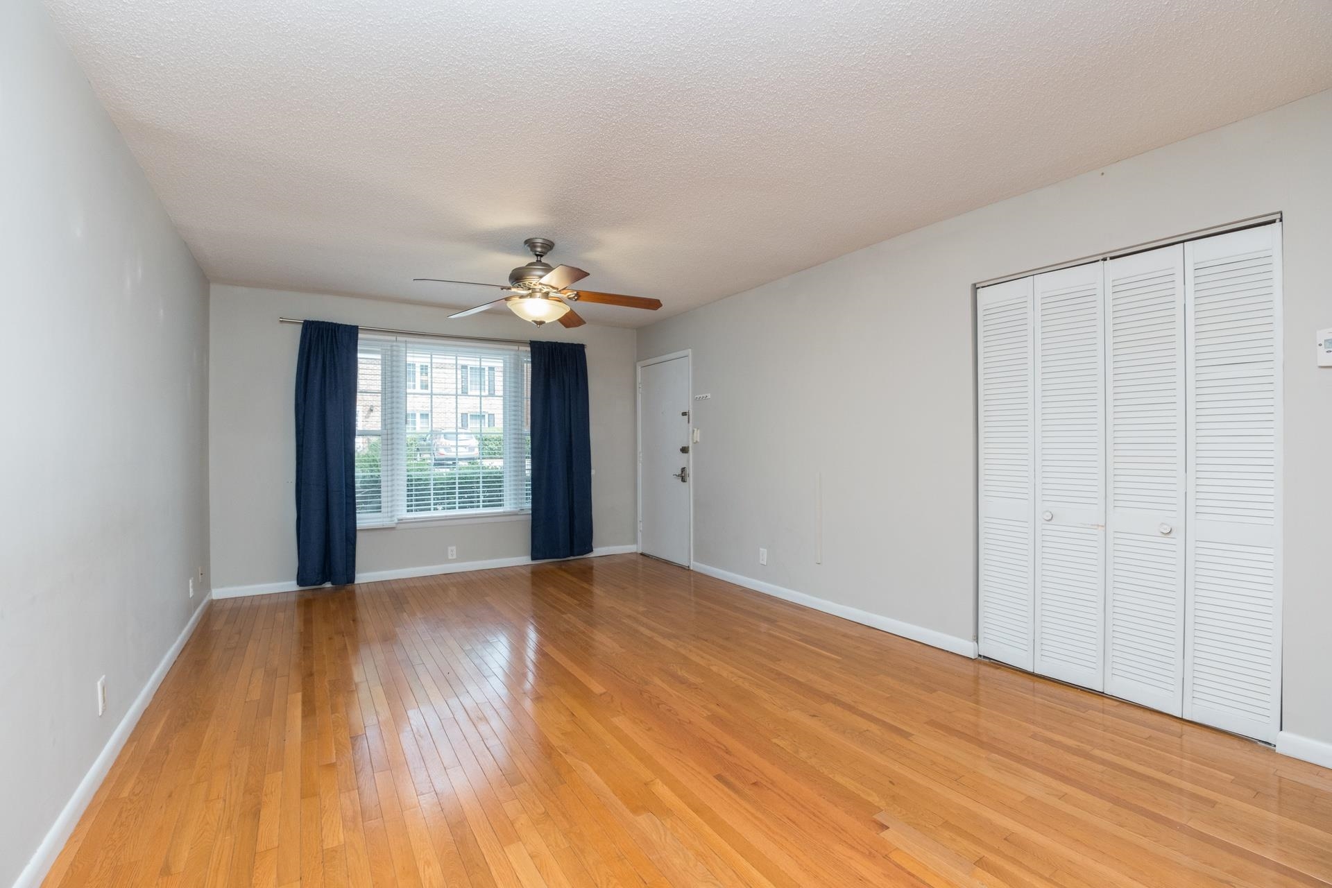 2527 Hydraulic Road, Unit 17 Charlottesville, VA 22901 - Photo 5 of 35 a view of an empty room with wooden floor and a window