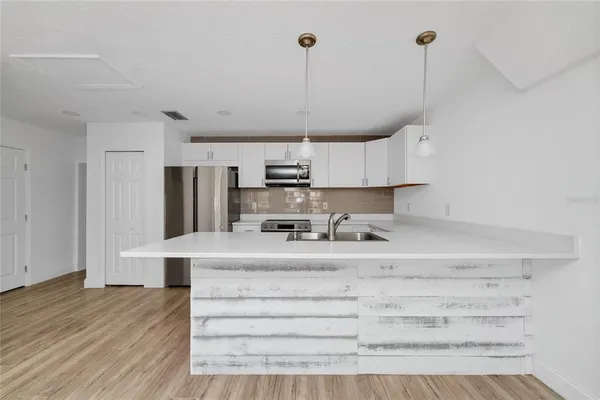 a kitchen with kitchen island stainless steel appliances a sink and cabinets