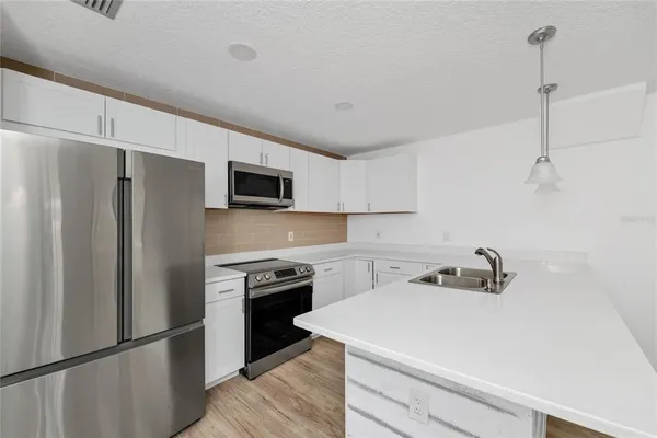 a kitchen with a sink a stainless steel appliances and cabinets