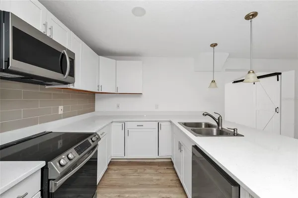 a kitchen with a sink and steel appliances