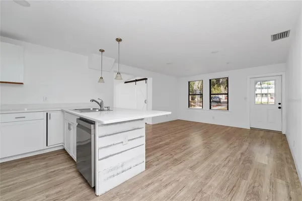 a kitchen with a sink cabinets and wooden floor