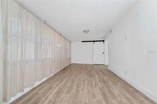 a view of an empty room with wooden floor