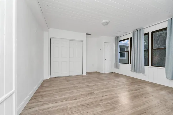 a view of an empty room with wooden floor