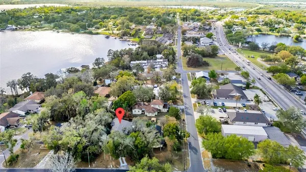 an aerial view of city and lake with trees all around