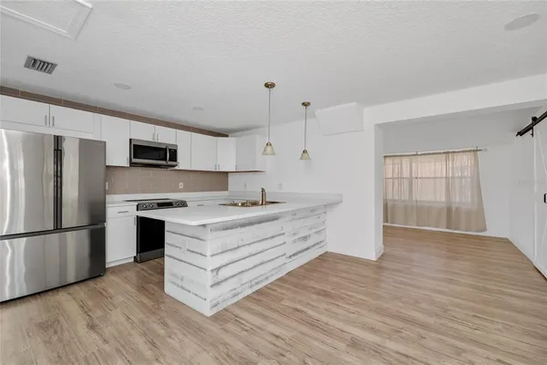 a kitchen with stainless steel appliances a refrigerator and a stove top oven