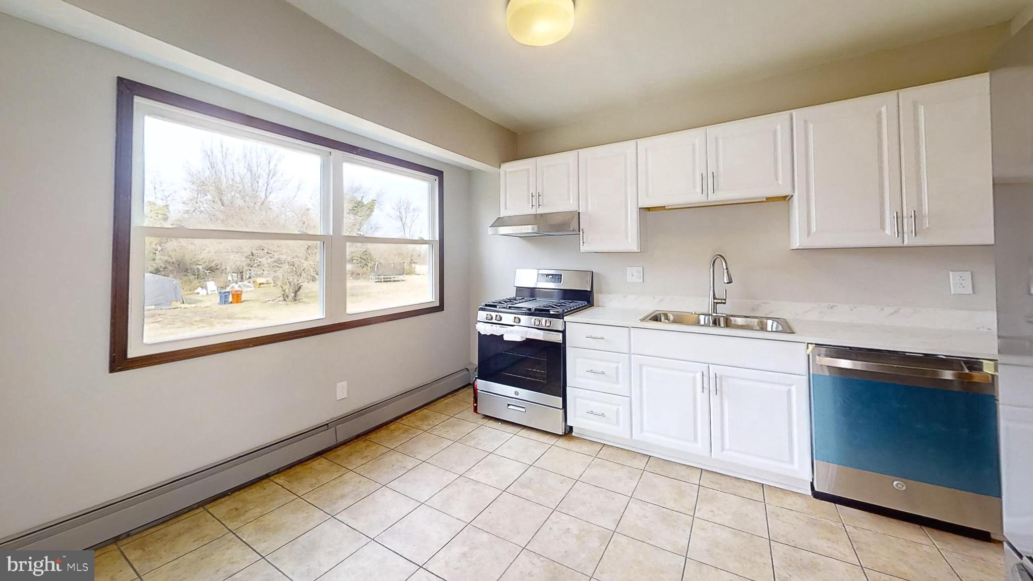 653 Buckshutem Road Bridgeton, NJ 08302 - Photo 11 of 29 a kitchen with a stove a sink and a window