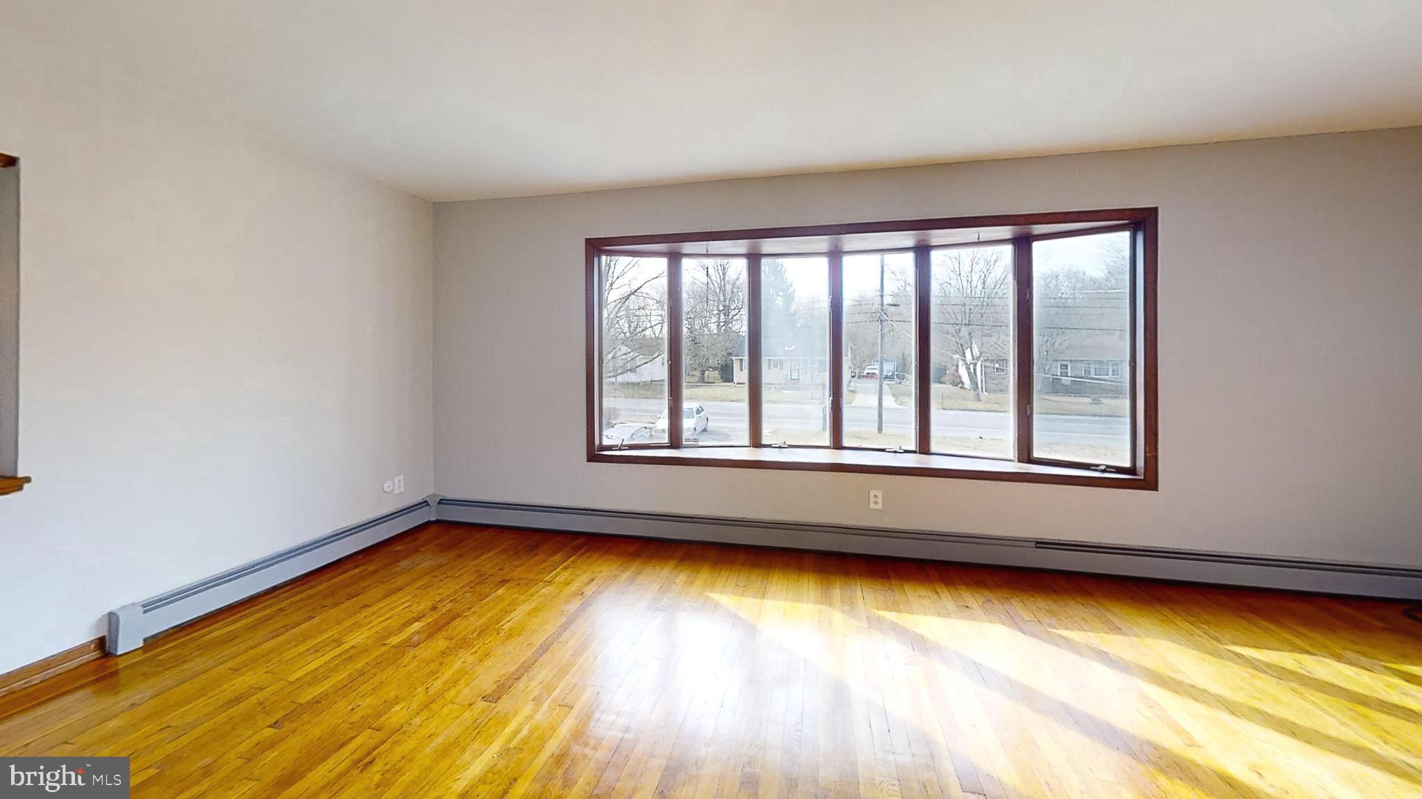 653 Buckshutem Road Bridgeton, NJ 08302 - Photo 6 of 29 a view of an empty room with a window and hardwood floor