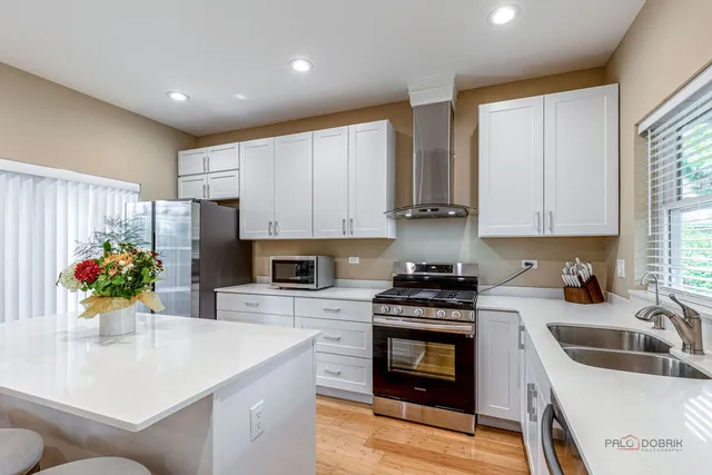 a kitchen with kitchen island granite countertop a sink stainless steel appliances and cabinets