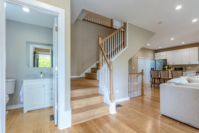 a view of a hallway view with wooden floor and a living room