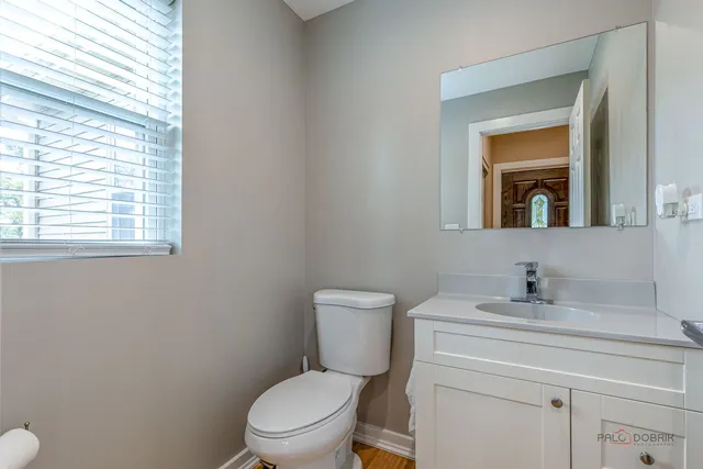 a bathroom with a toilet sink vanity and mirror