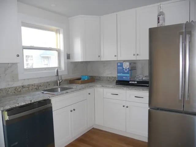 a kitchen with granite countertop white cabinets white appliances and a granite counter tops