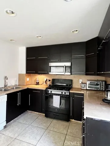 a kitchen with stainless steel appliances a stove sink and cabinets