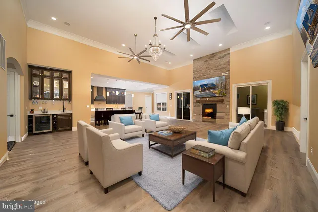 a living room with furniture kitchen view and a wooden floor