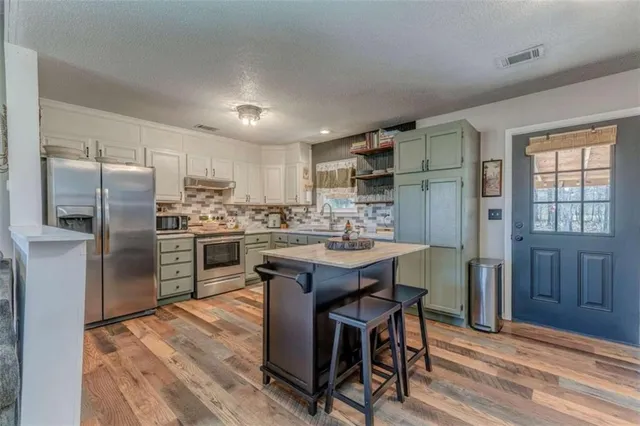 a kitchen with a refrigerator a sink dishwasher and wooden cabinets