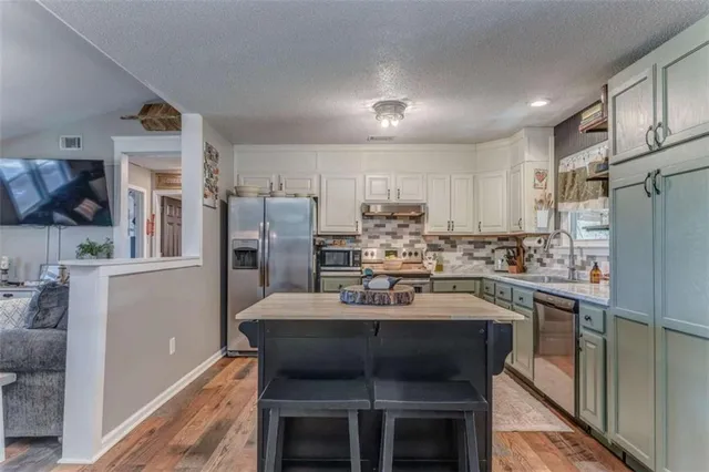 a kitchen with stainless steel appliances a refrigerator stove microwave and cabinets