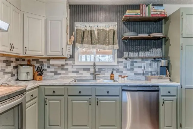 a kitchen with granite countertop a sink a window and cabinets