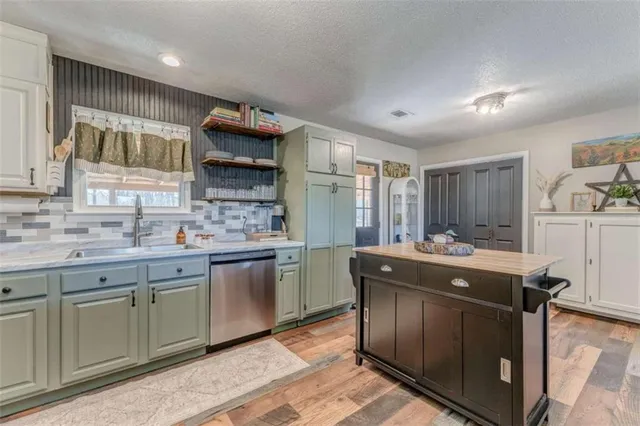 a kitchen with a stove sink and cabinets