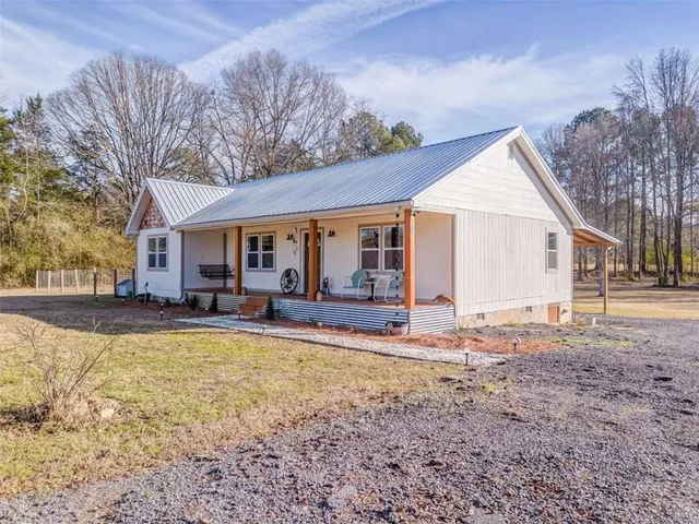 a view of a house with a yard and sitting area