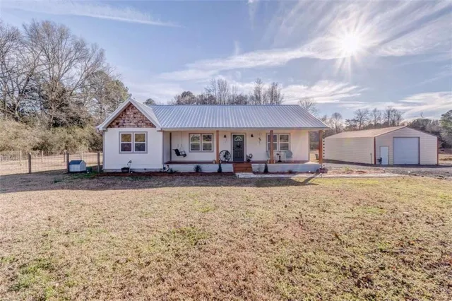 a view of house with yard and sitting area