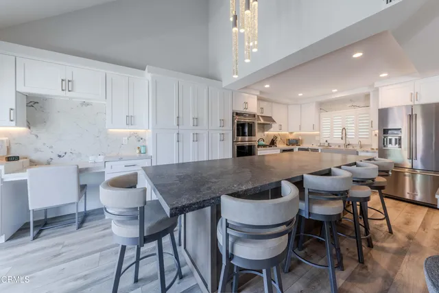 a kitchen with a dining table chairs and white cabinets