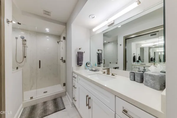 a bathroom with a double vanity sink toilet mirror and shower